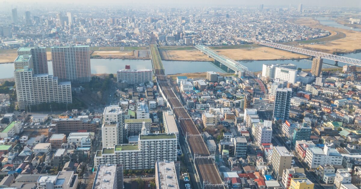 都市部を流れる川と鉄道橋を上空から捉えた市街地の風景