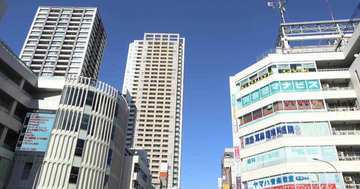 高層マンションと商業ビルが立ち並ぶ都市の街並み
