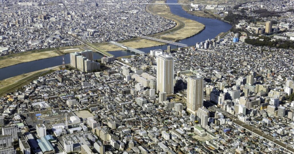 河川と高層マンションが広がる都市の全景を上空から撮影