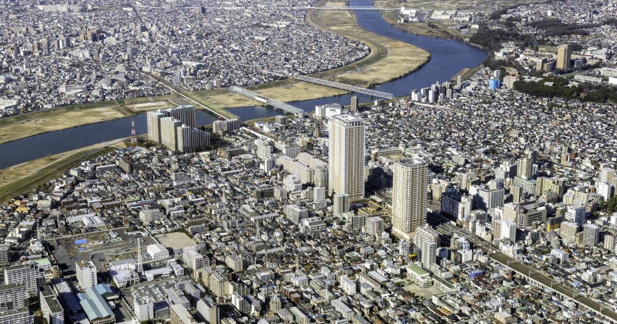 河川と高層マンションが広がる都市の全景を上空から撮影