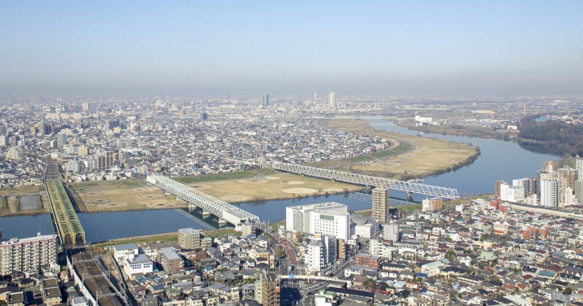 蛇行する川と橋が連なる市街地を俯瞰した風景