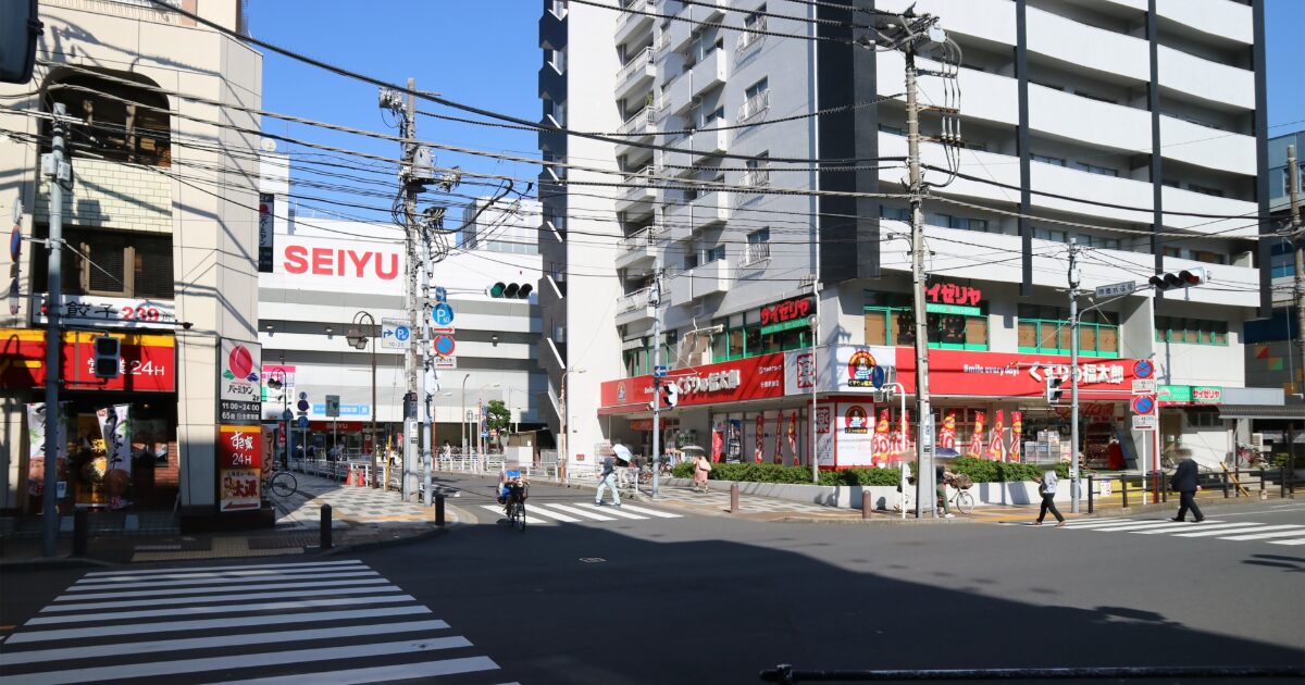 西友や飲食店が並ぶ交差点の都市風景