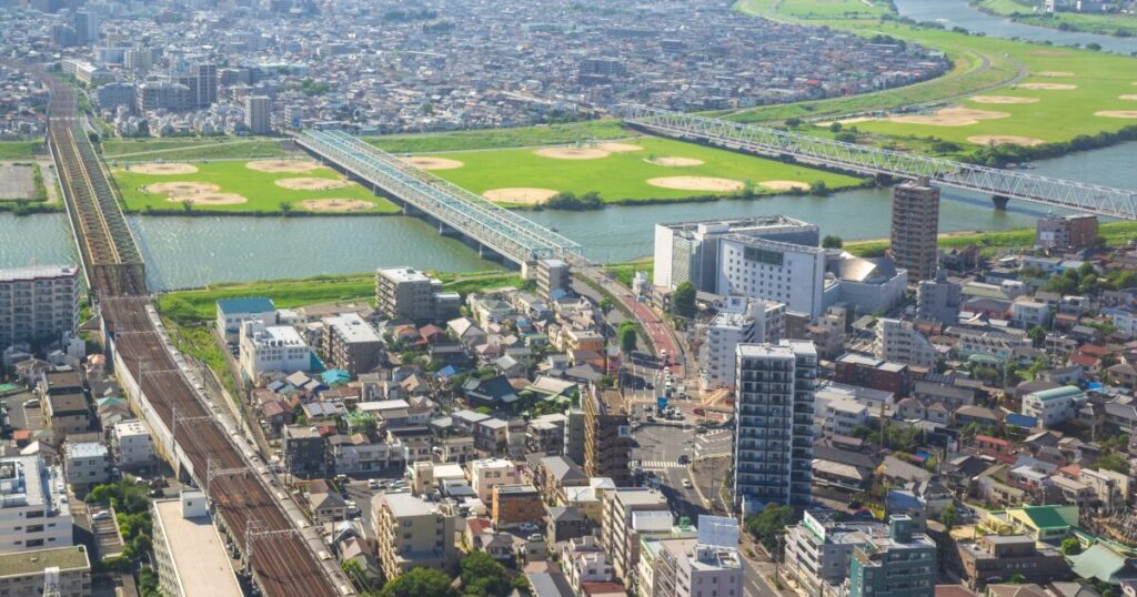 鉄道橋と住宅街が広がる河川沿いの俯瞰風景