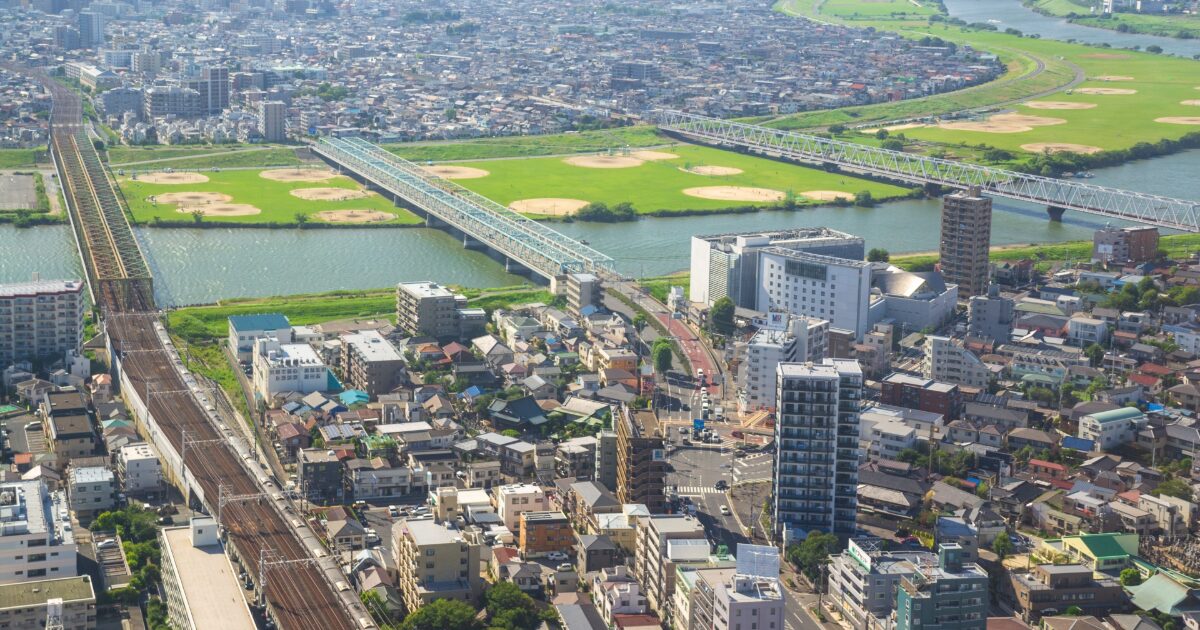 鉄道橋と住宅街が広がる河川沿いの俯瞰風景