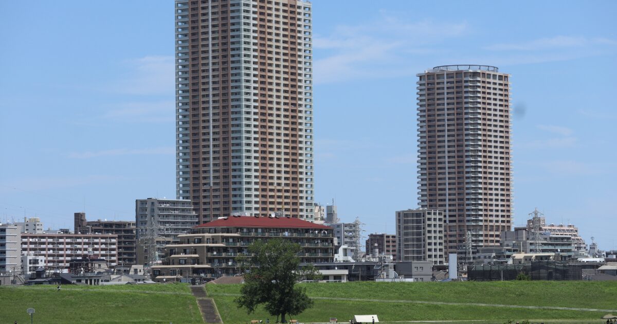 高層マンションが並ぶ都市住宅エリアと河川敷の風景