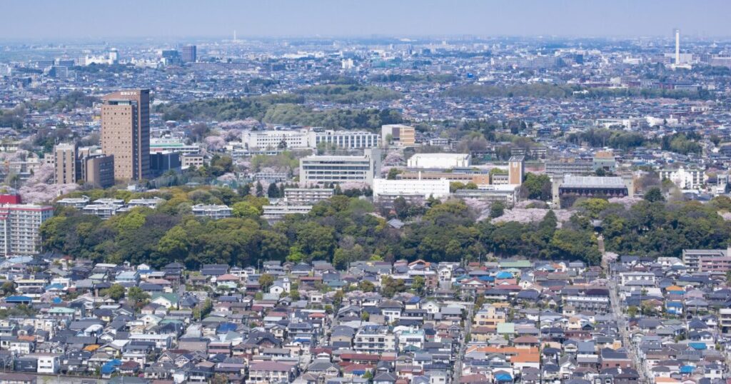 桜が咲く住宅地と大学施設を上空から捉えた春の景色