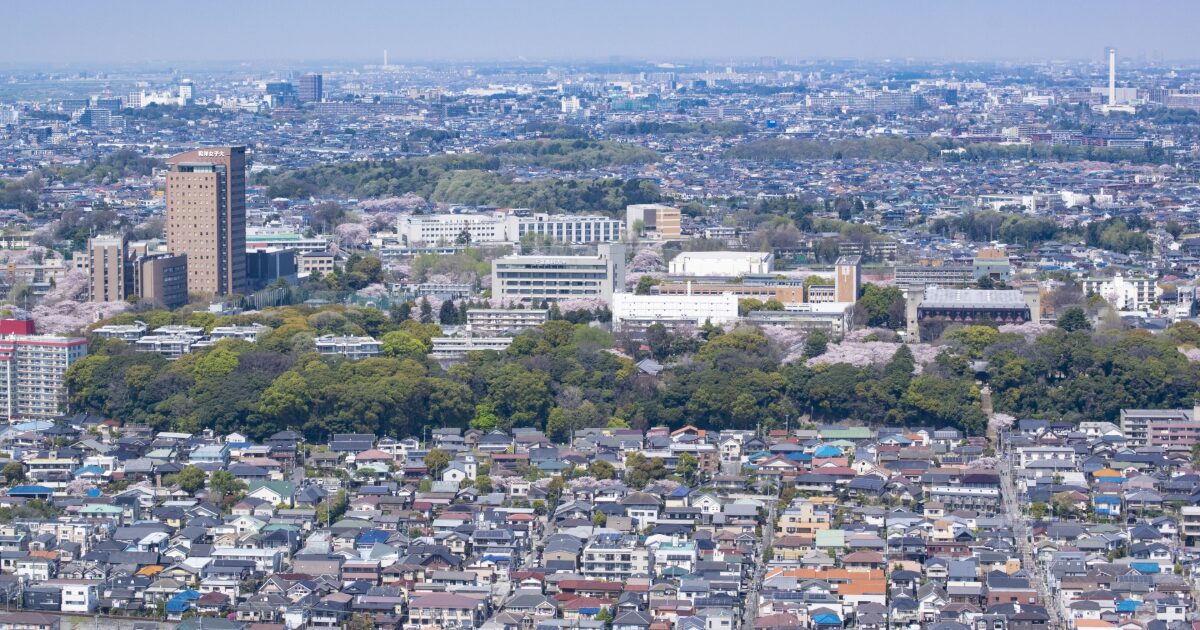 桜が咲く住宅地と大学施設を上空から捉えた春の景色
