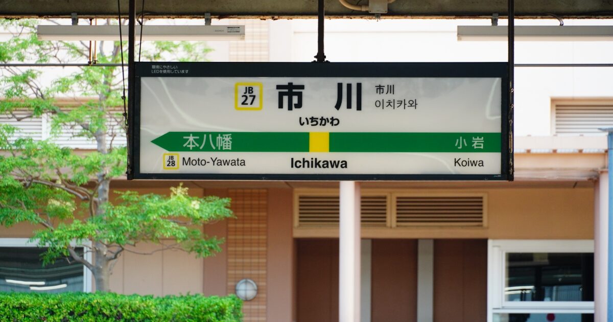 市川駅の駅名標と周辺のホーム風景を捉えた写真