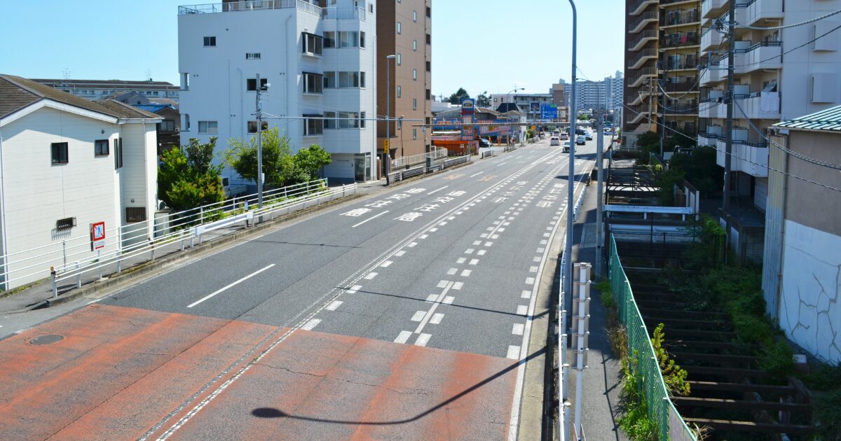 都市部の幹線道路とマンションが並ぶ街並み