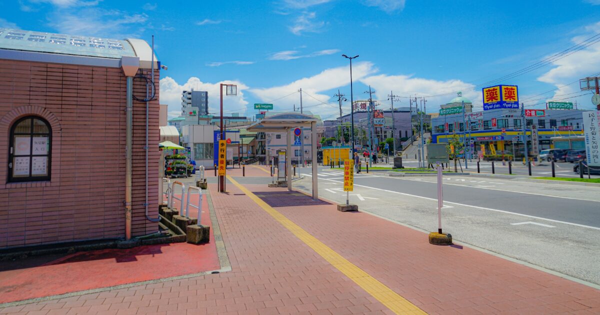 郊外の道路とバス停商業施設が並ぶ街並み