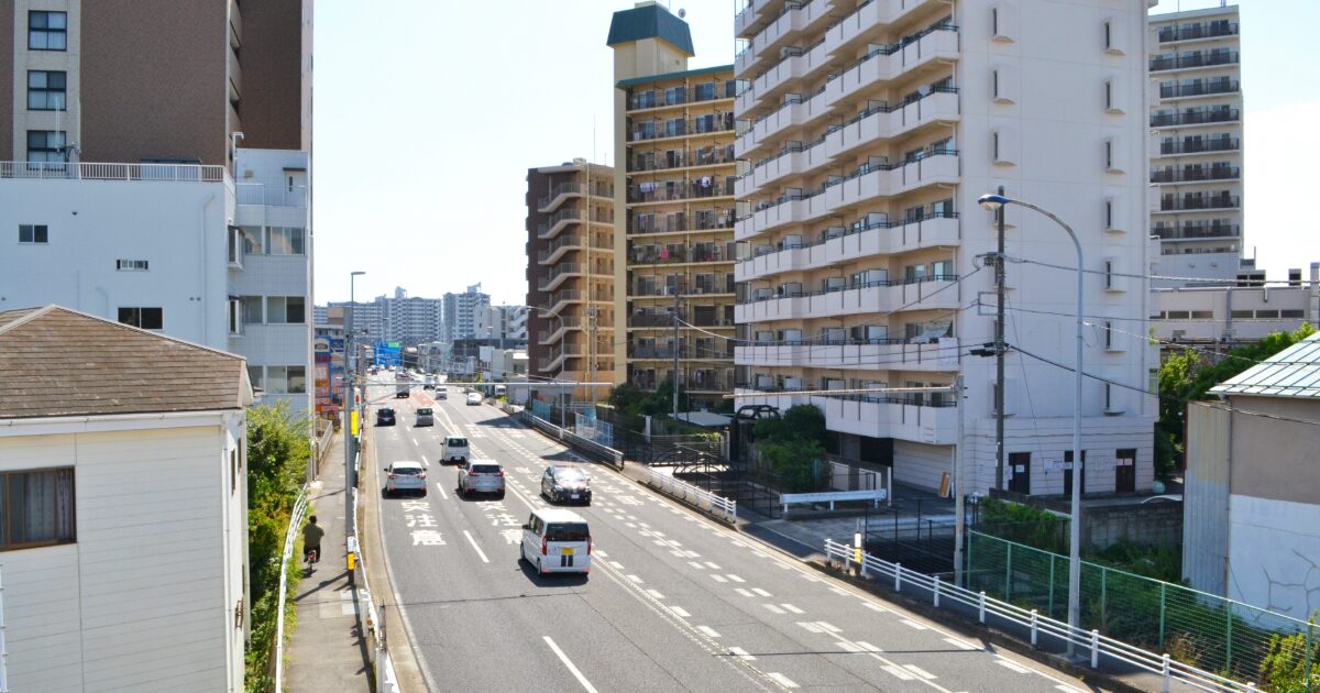 幹線道路沿いにマンションが並ぶ都市の街並み