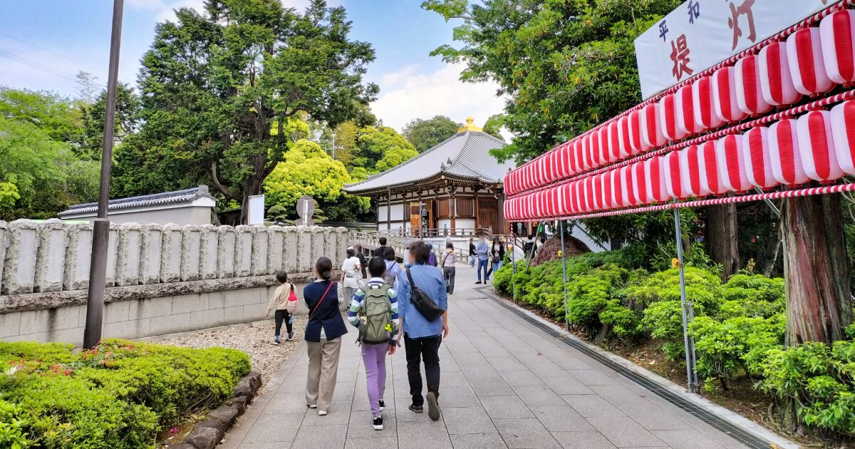 参拝客が歩く寺院参道と緑に囲まれた境内